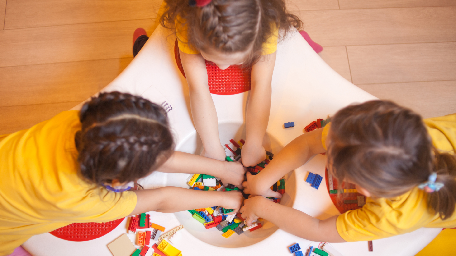 Crianças brincando juntas em uma mesa educativa